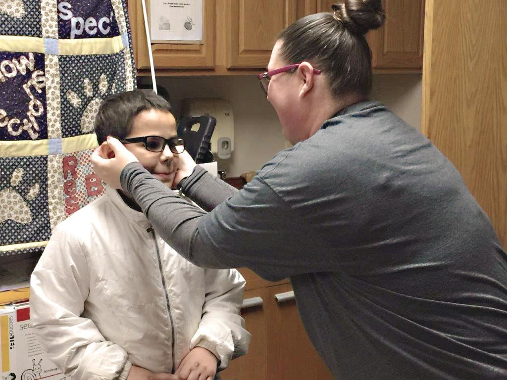 Staff helps student with glasses 